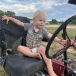 Cooper loves to "drive" the tractors here he is on the old Farmall Cub