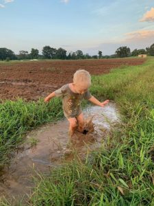 Cooper splashing ina puddle along the field