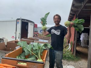 Patrick holding up some big kohlrabi