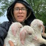 Farmer Josephine carrying three baby goats