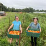 Melea (L) and Skylar (R) showing the paste tomatoes they just harvested