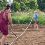 Cooper helping Josephine set up the header for the drip irrigation