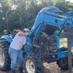 Josephine changing the fan belt on Ol' Blue