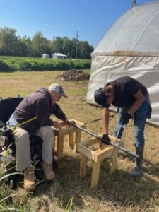 Randy (L) and Robin (R) cutting poles as they work on repairing a high tunnel