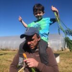 David with Calvin on his shoulders enjoying fresh picked carrots