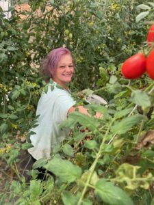 Kayla picking tomatoes in the high tunnel