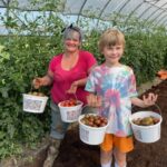 Kayla (L) and Cooper (R) with the first round of cherry tomatoes.