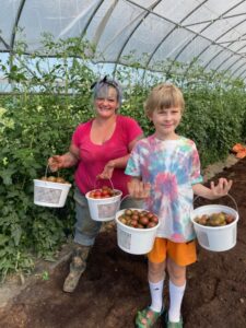 Kayla (L) and Cooper (R) with the first round of cherry tomatoes.
