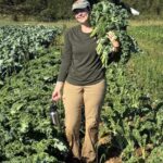 May not feel like it but seasons are changing. Here is Shelby with an armload of bunched kale.