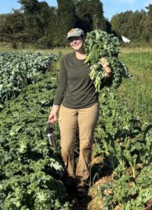 May not feel like it but seasons are changing. Here is Shelby with an armload of bunched kale.