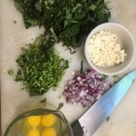 Chopped sweet potatoes, garlic,onions, eggs and a knife