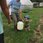 Cooper helping carry the chicken waterer
