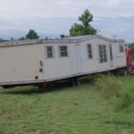 The trailer being backed into the property.